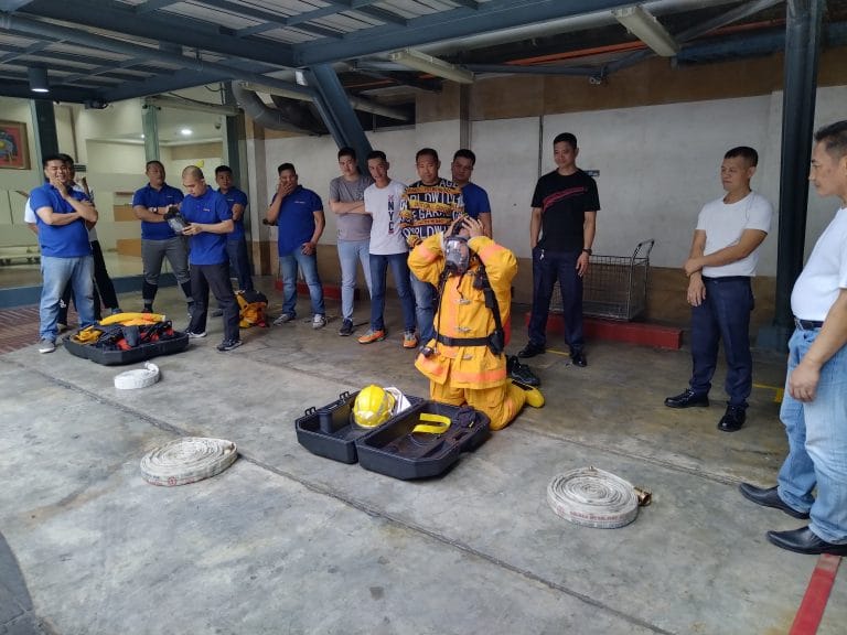 Personnel demonstrating firefighting protective gear during a safety drill