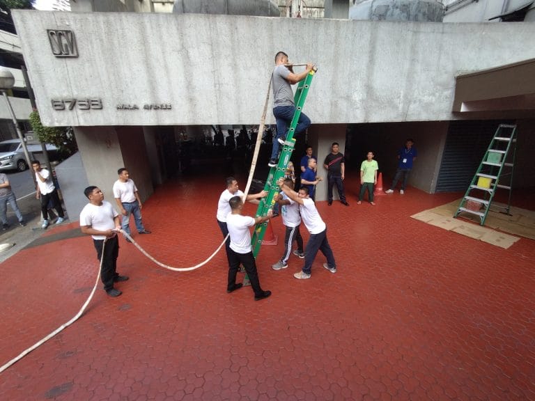 Fire safety drill with a ladder and pressurized hose