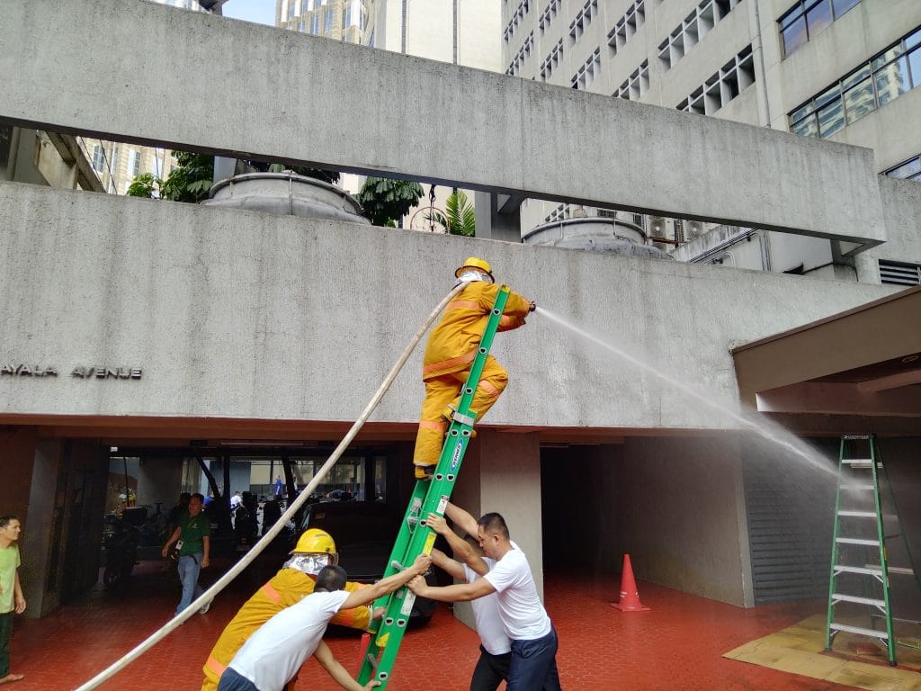 Airborne personnel training with a fire hose and ladder during a fire safety drill